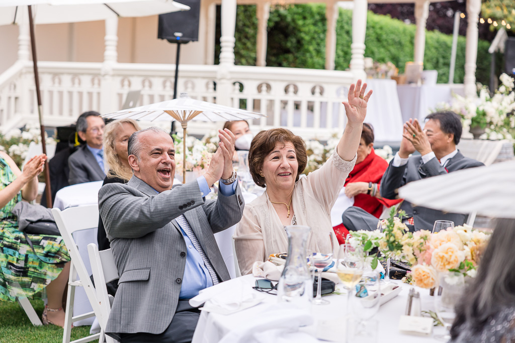 parents of the groom clapping and cheering during dinner speeches