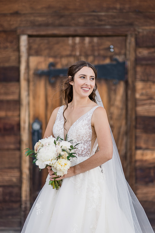bride solo portrait in front of rustic wooden door