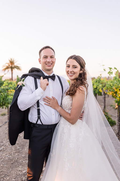 casual wedding photo with jacket slung over shoulder