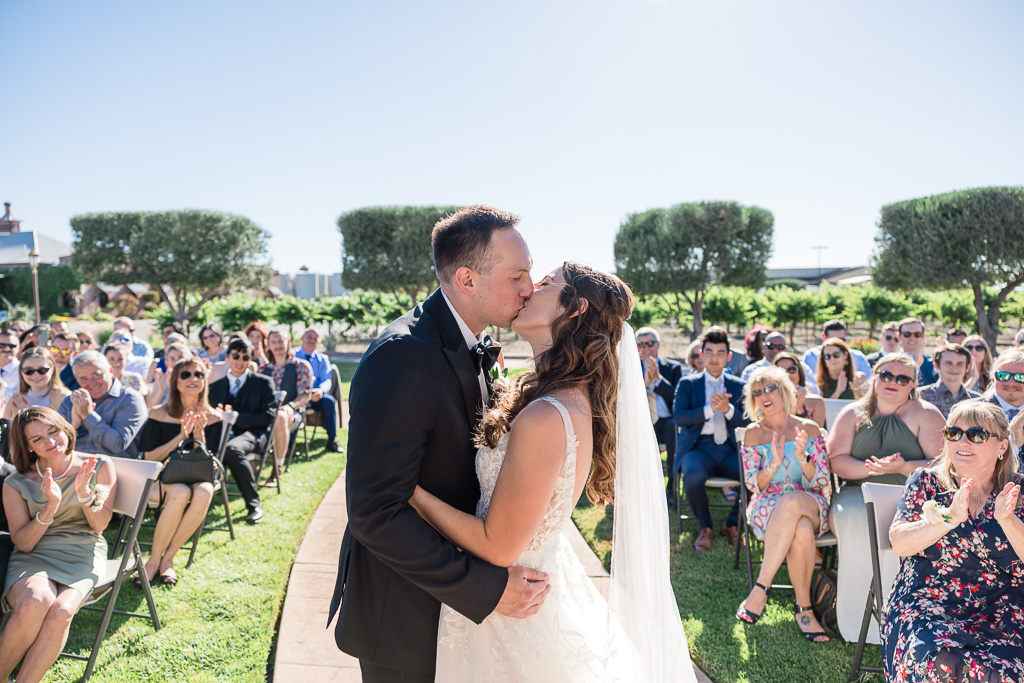 creative first kiss photo from behind the altar showing guest reactions