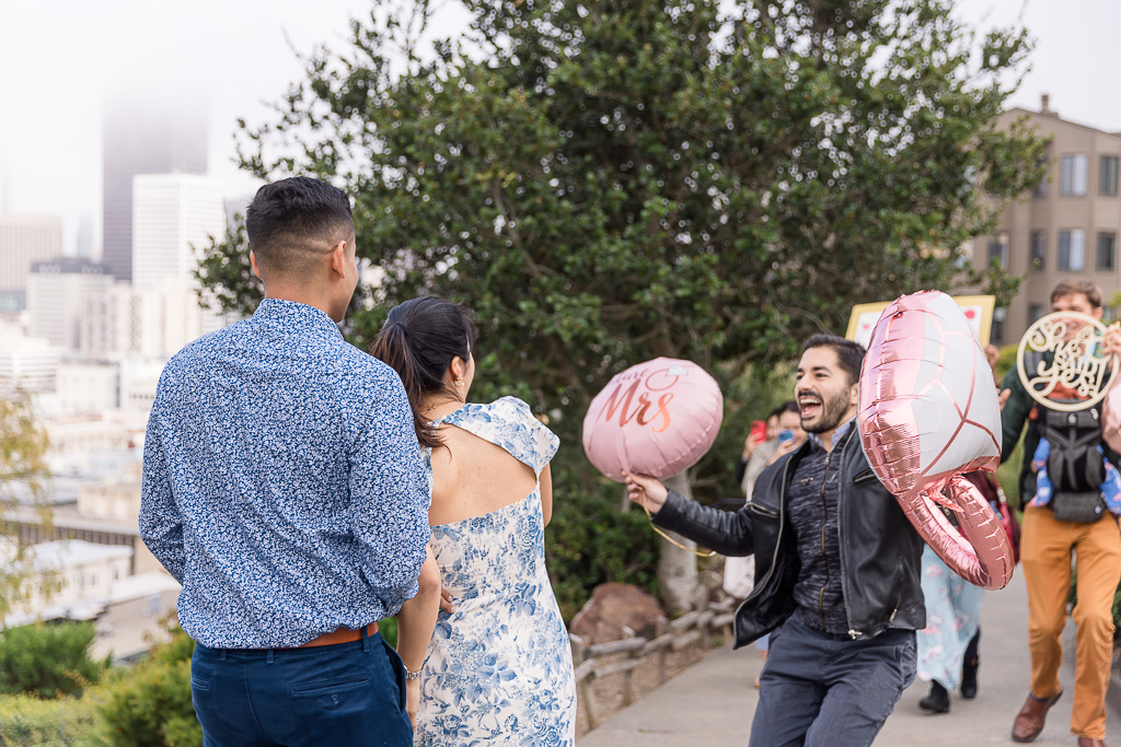 friends surprising newly-engaged couple to congratulate them
