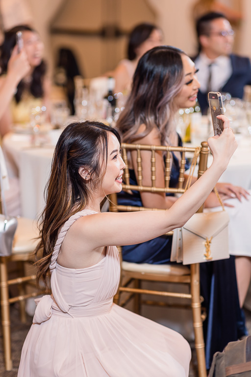 guests at wedding reception taking phone photos