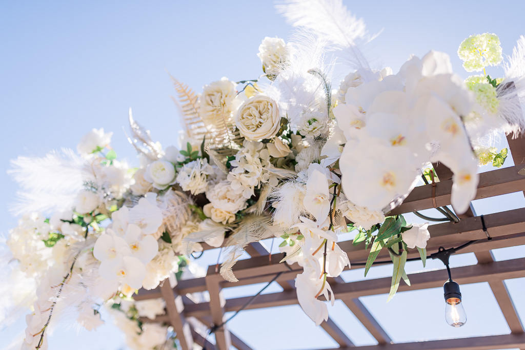 Floral decor at wedding ceremony trellis by Flower Divas