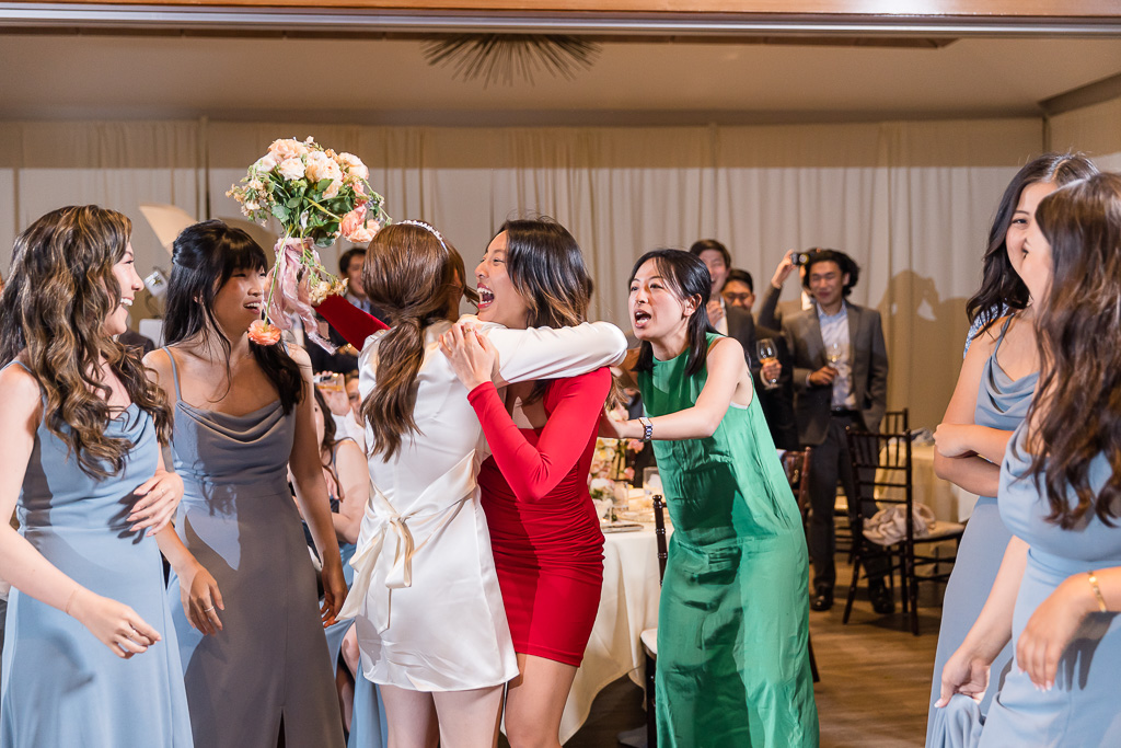 bride hugging her friend who caught the tossed bouquet