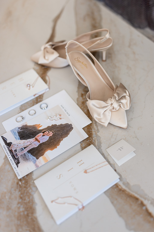 wedding flatlay with shoes and invitations and jewelry