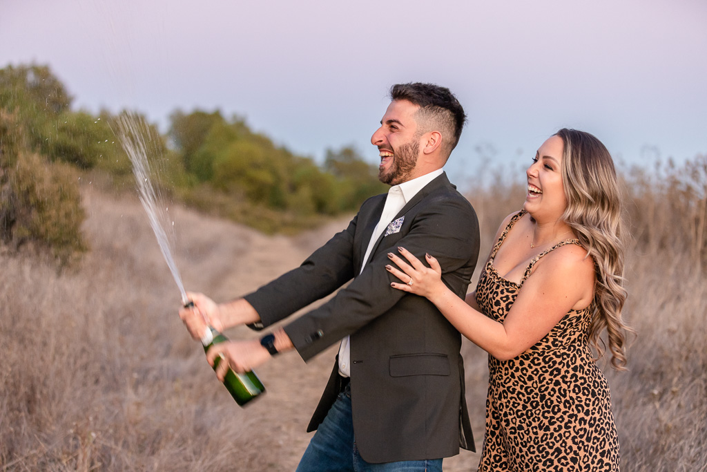 excited champagne popping/spraying engagement photo