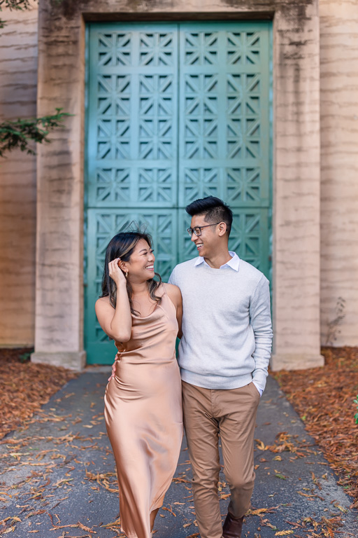 stylishly dressed couple taking engagement photos at the Palace of Fine Arts