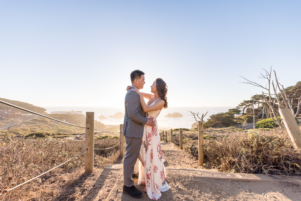 engagement pics at the top of Sutro Baths with the ocean sunset