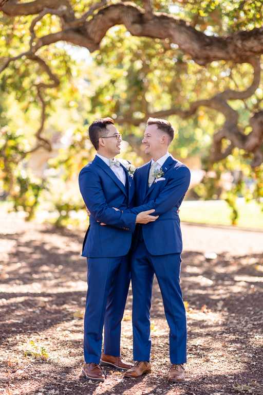 two grooms embracing and looking at each other lovingly