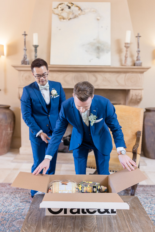groom opening a big gift box from his groom as a wedding present