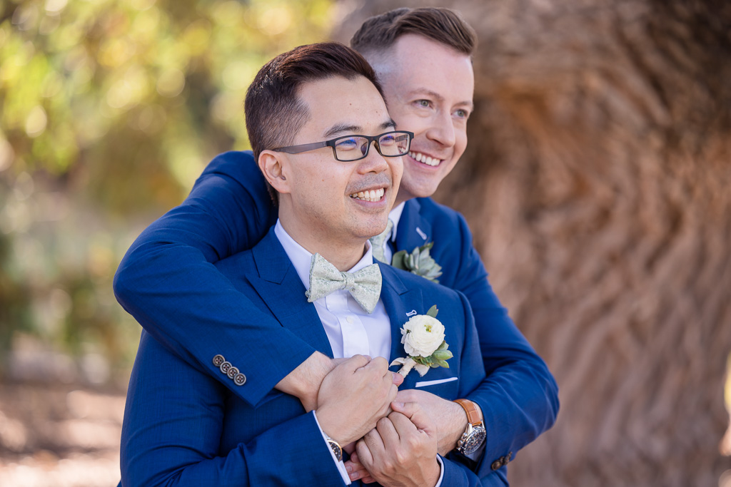 grooms with arms around each other
