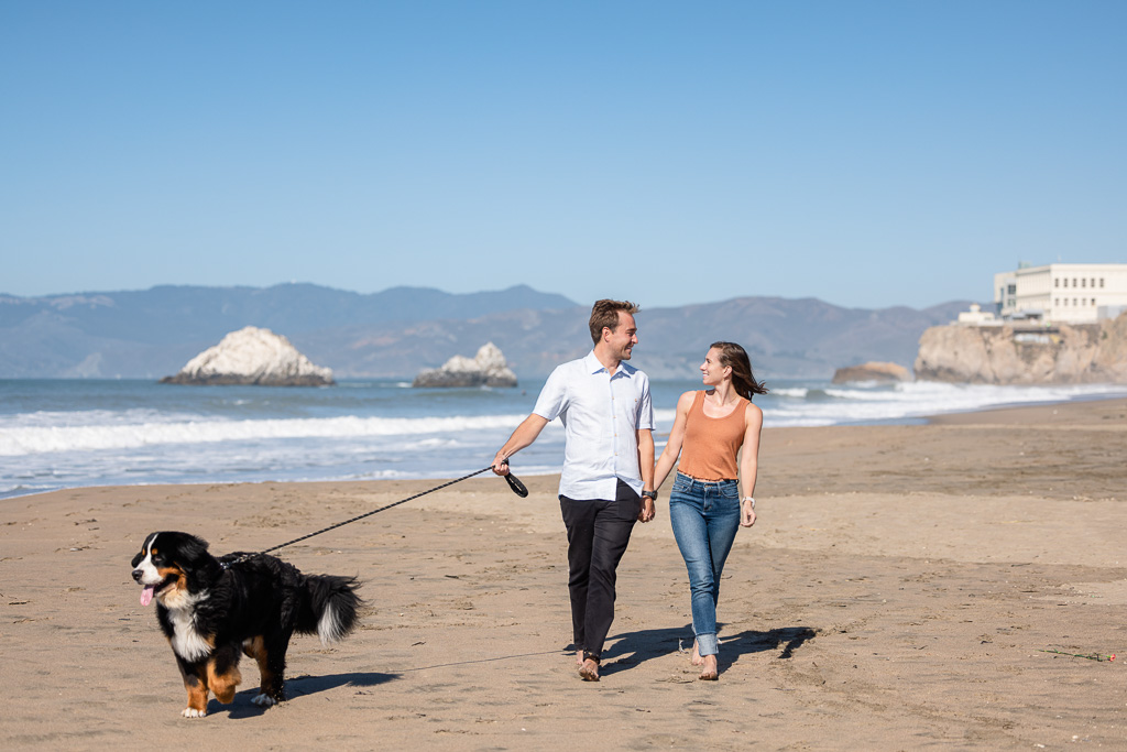 couple walking their dog at Ocean Beach below the Cliff House