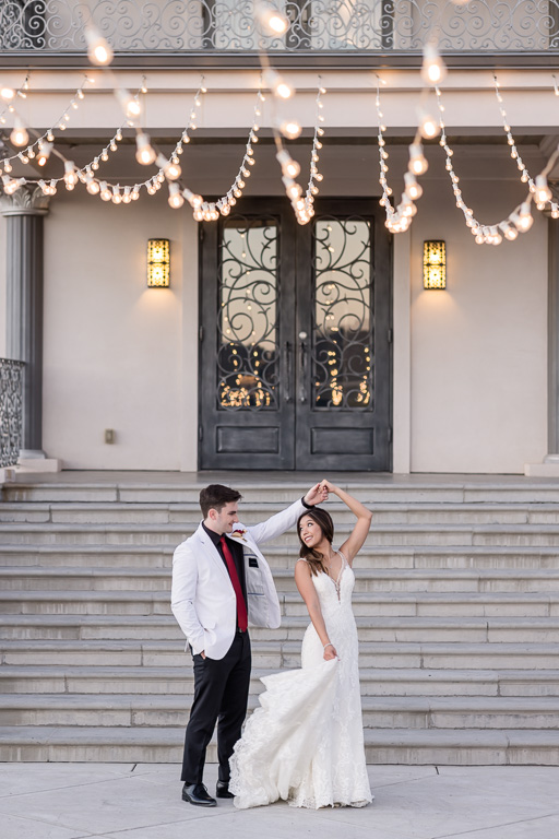 wedding portraits in front of the Willow Heights Mansion with string lights above