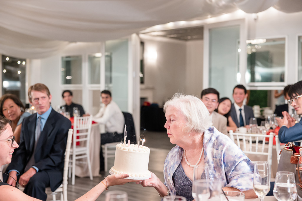 80 year old grandma blowing out candles at wedding