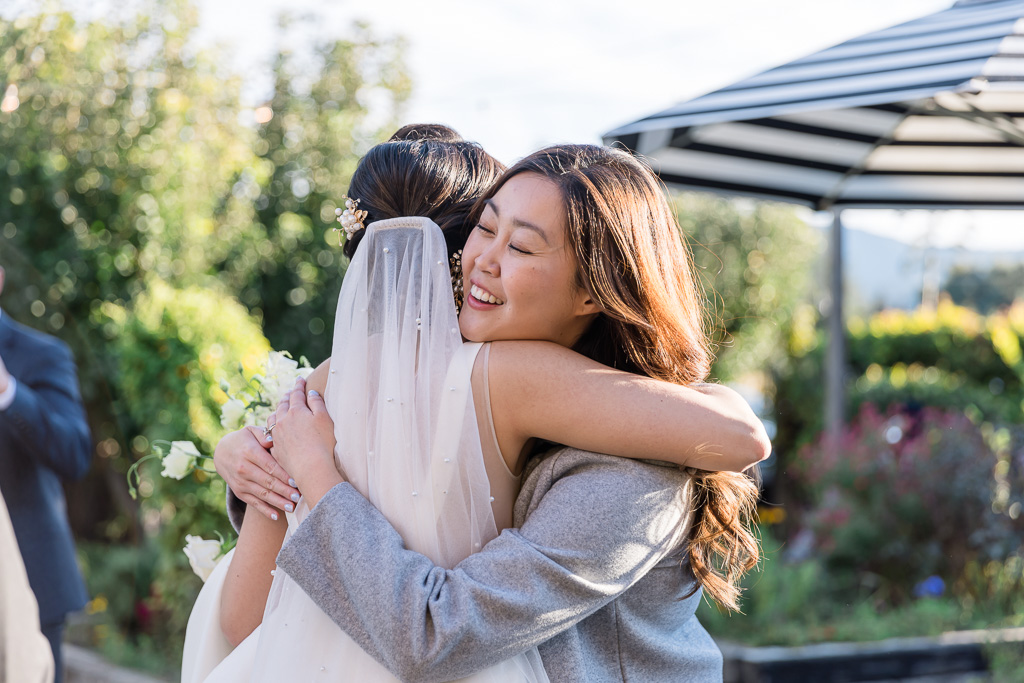bride hugging a friend during cocktail hour