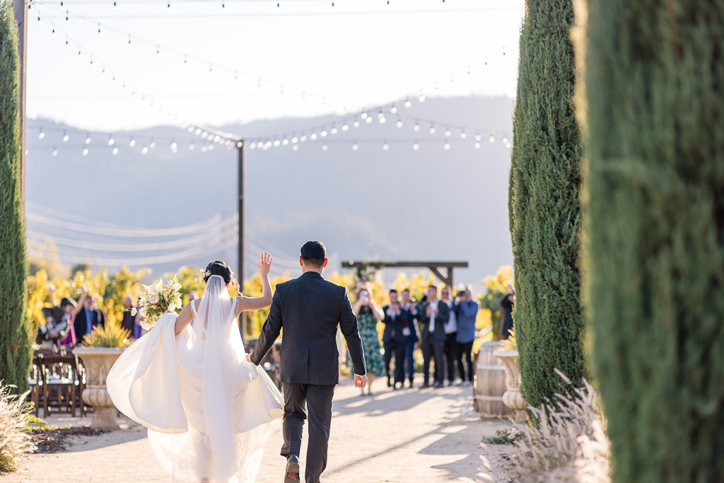 bride and groom walking towards guests