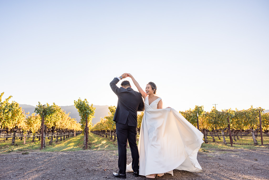 bride and groom doing a little dance in the vineyards behind Tre Posti