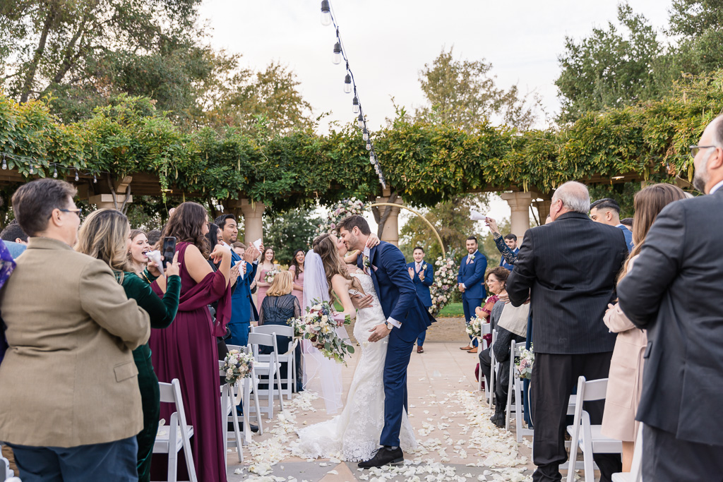 dip and kiss in the middle of the aisle during wedding ceremony recessional