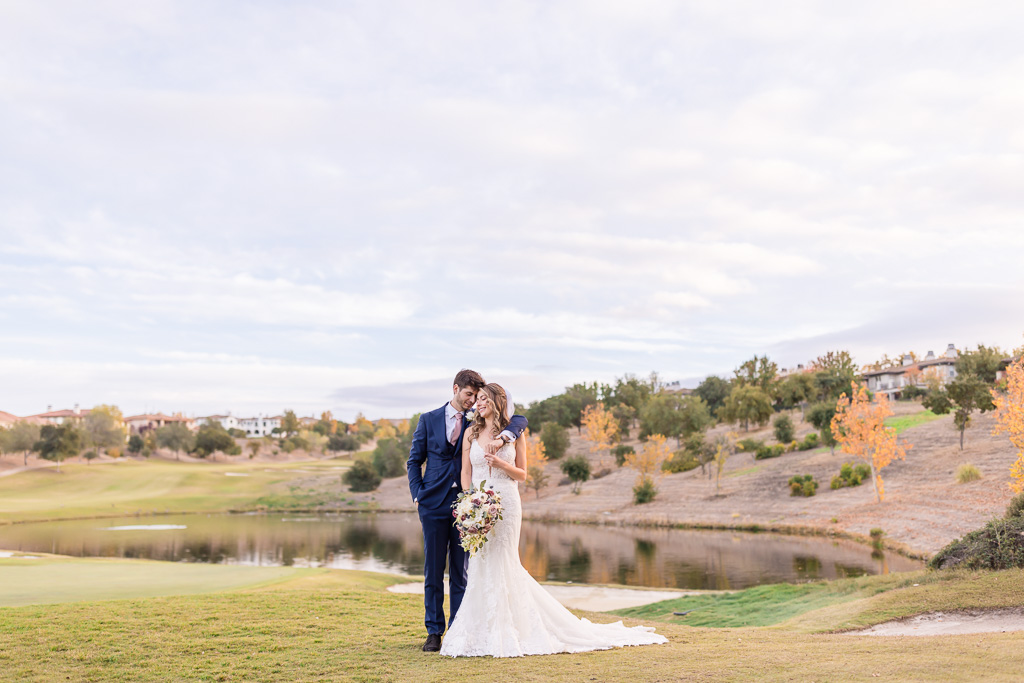 colorful autumn wedding photo with orange and yellow leaves in front of a lake