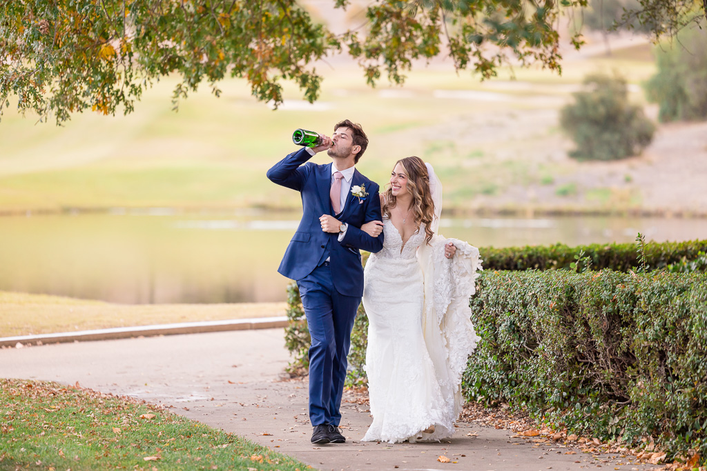 groom drinking champagne straight out of the bottle
