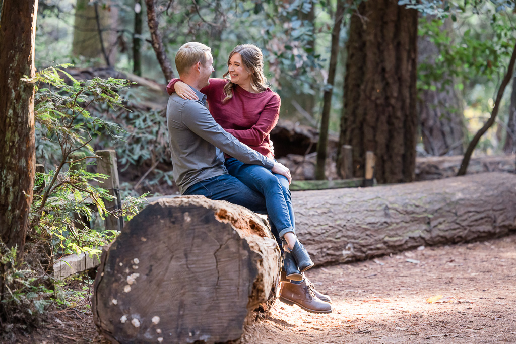 couple sitting on a giant log for engagement photos