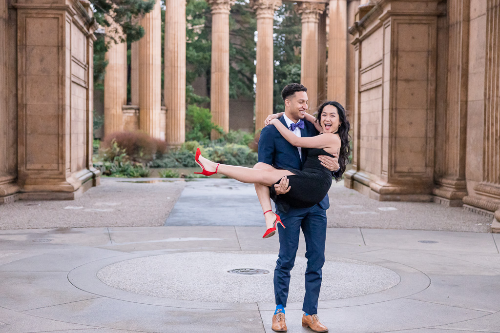 cute lifting up couple photo with black dress and red shoes