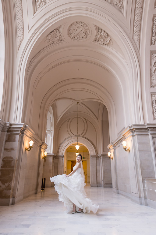 bride playing with wedding dress at City Hall