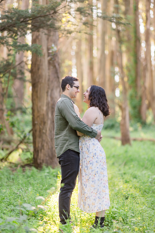 cute engagement photos in the woods with magical golden light sprinkling down
