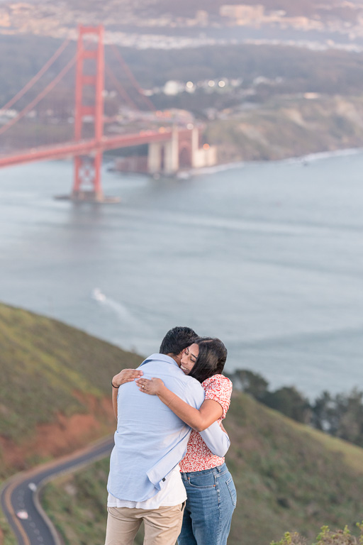 couple hugging on a hill high above the Golden Gate Bridge