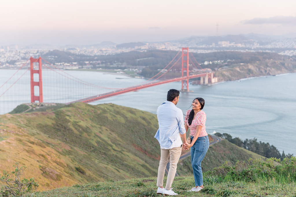 couple standing on a hill in front of the Golden Gate Bridge