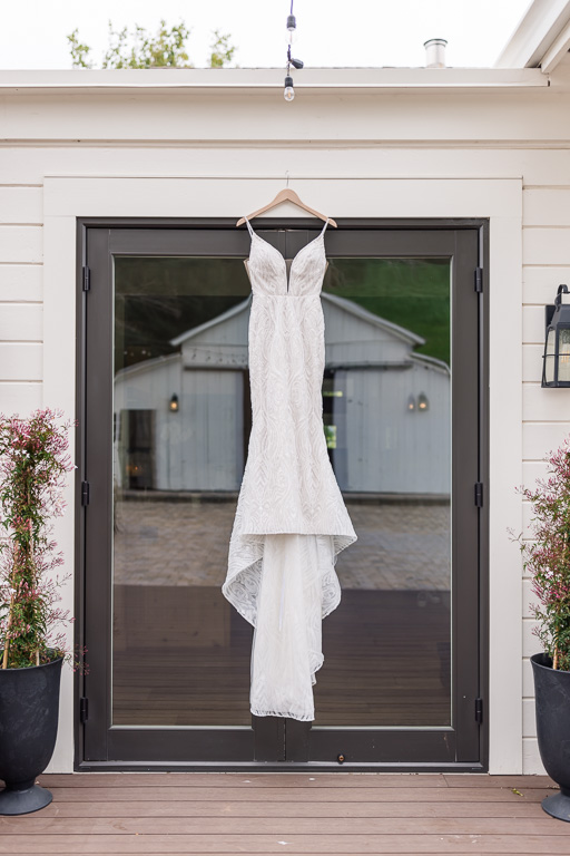 wedding gown hanging on a glass door