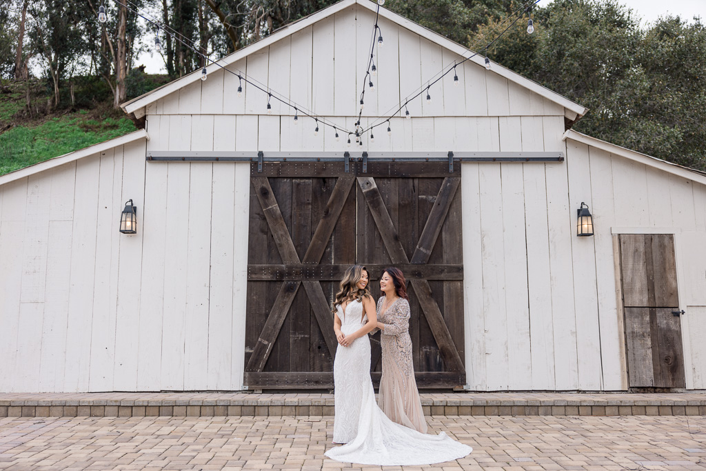 Casa Real wedding bride putting on dress in front of a barn