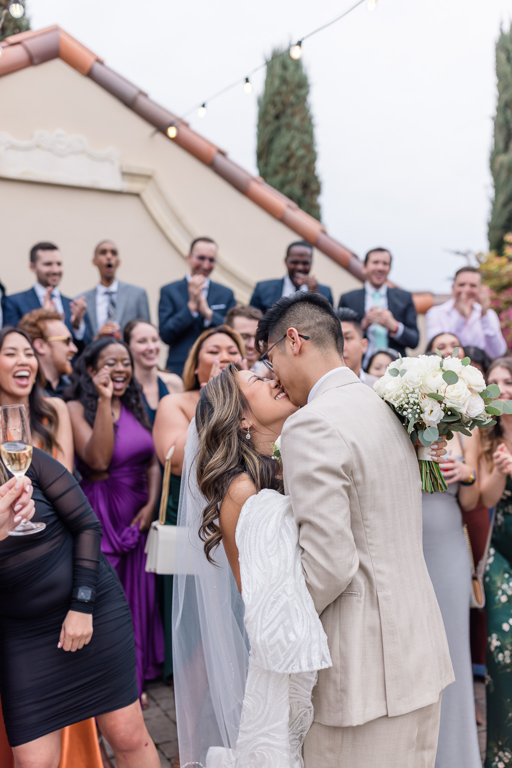 a candid cheering and kissing moment while taking group photos with friends