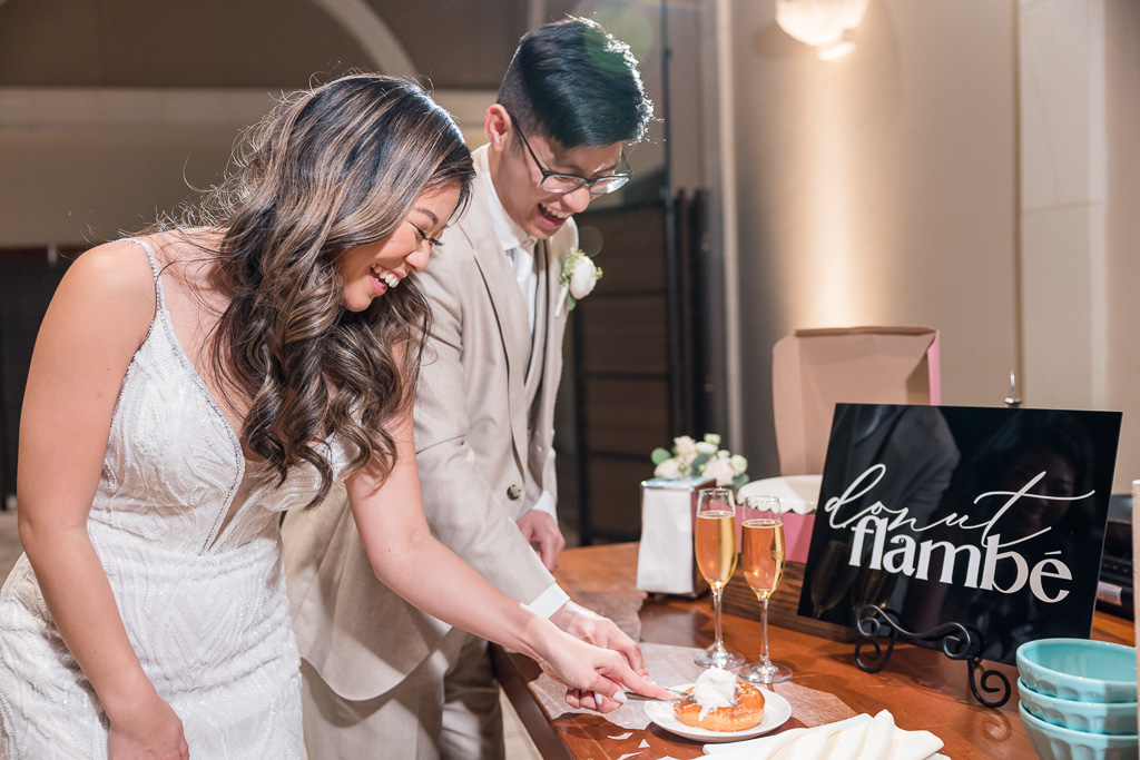 newlyweds cutting their wedding donut flambé