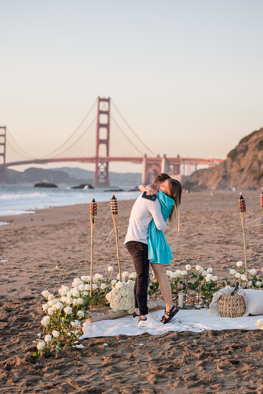 romantic proposal decor on the beach with white long stem roses