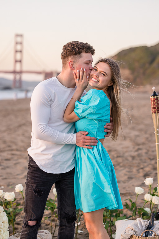 cute couple taking engagement photos at Baker Beach