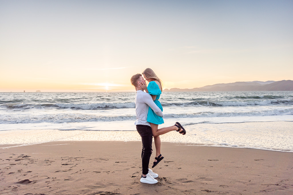 engagement photos against the sunset at a beach by the ocean