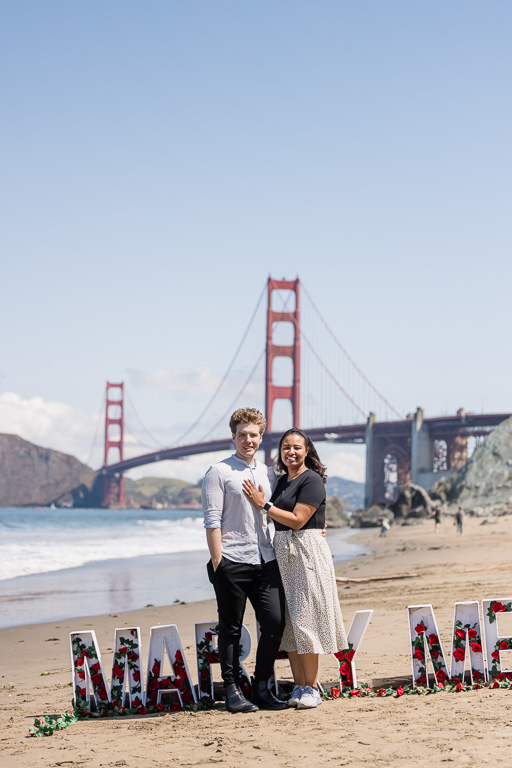 photo in front of the Golden Gate Bridge with marry me sign