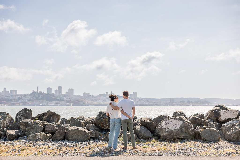 couple enjoying the sunshine and looking at the San Francisco skyline from Treasure Island