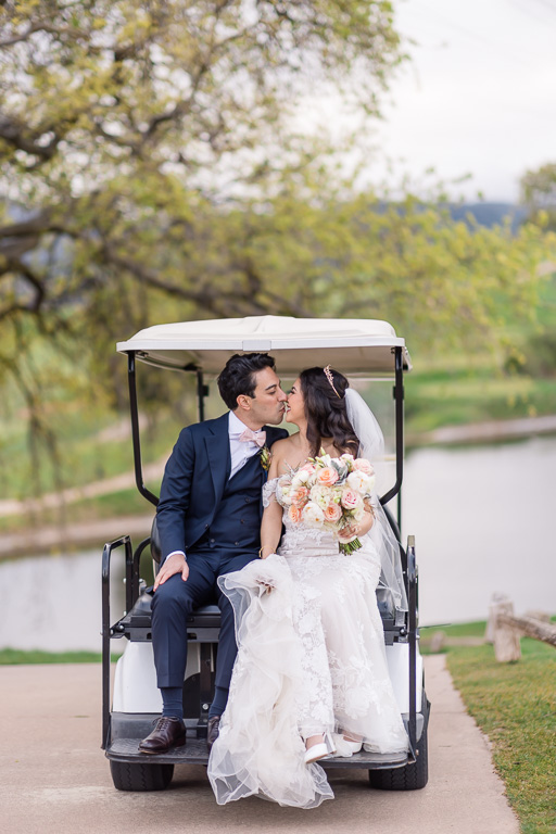 bride and groom kissing in a golf cart