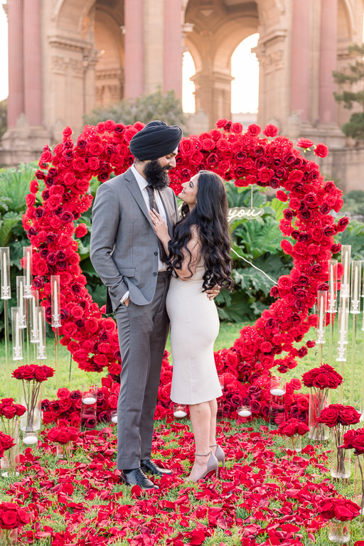 engagement photos in front of rose petal heart