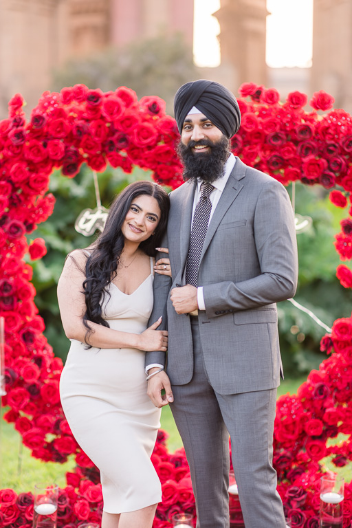 photo of engaged couple in front of rose heart