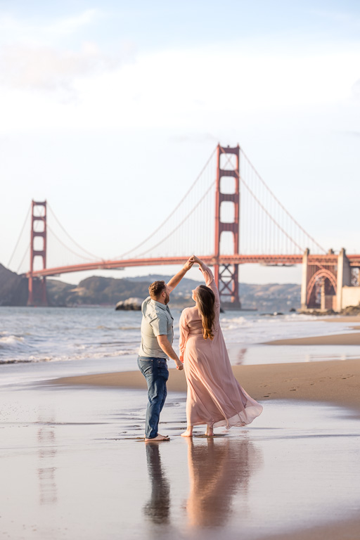 dancing on the beach in front of the Golden Gate Bridge