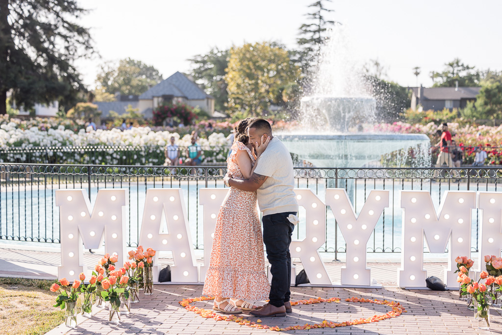 surprise proposal in front of giant MARRY ME sign and letters