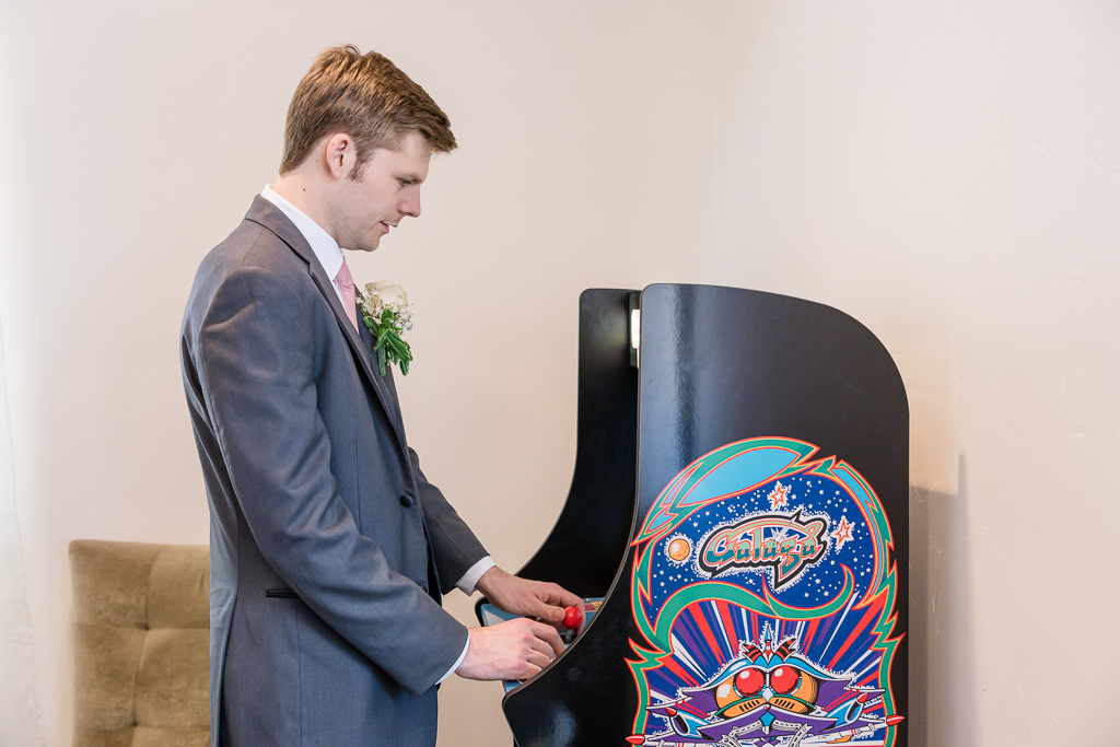 groom playing an arcade game machine just before the wedding