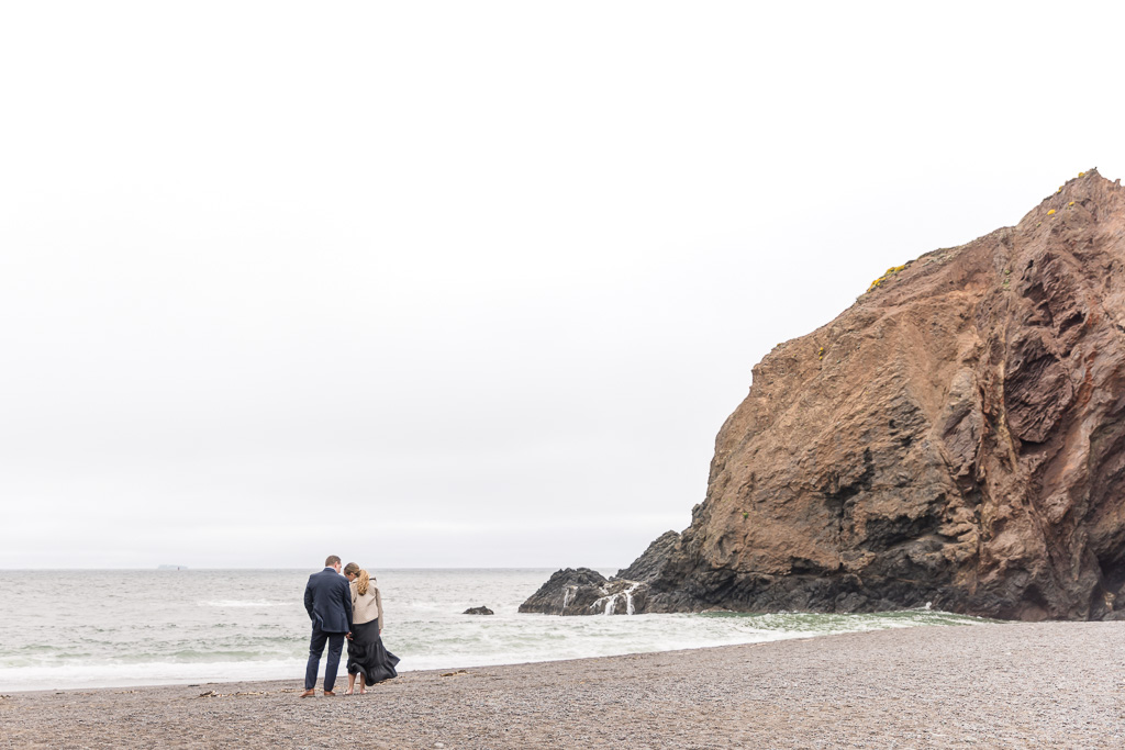 couple standing on the shore of Tennessee Beach in Marin County