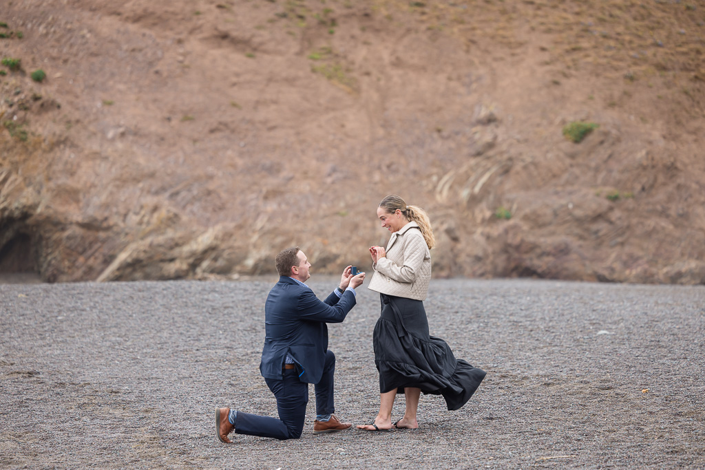 proposal on beach with dark sand