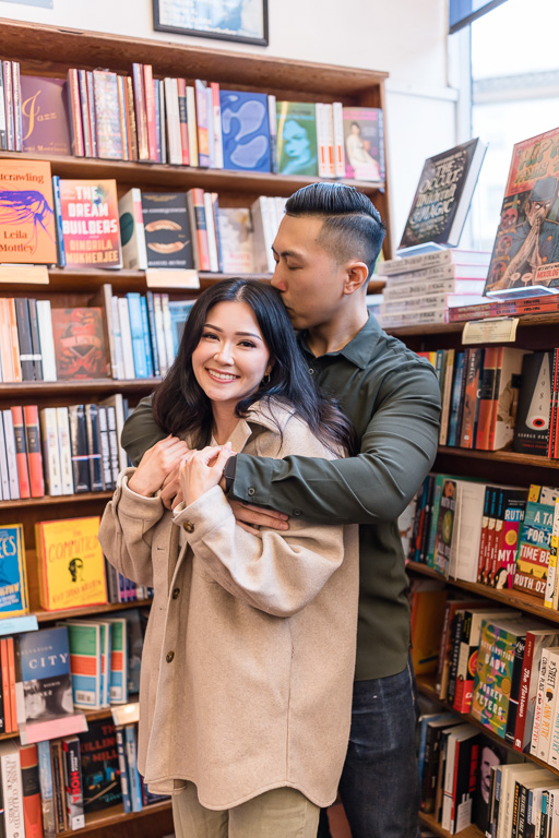 couple portraits inside a bookstore in front of shelves of books