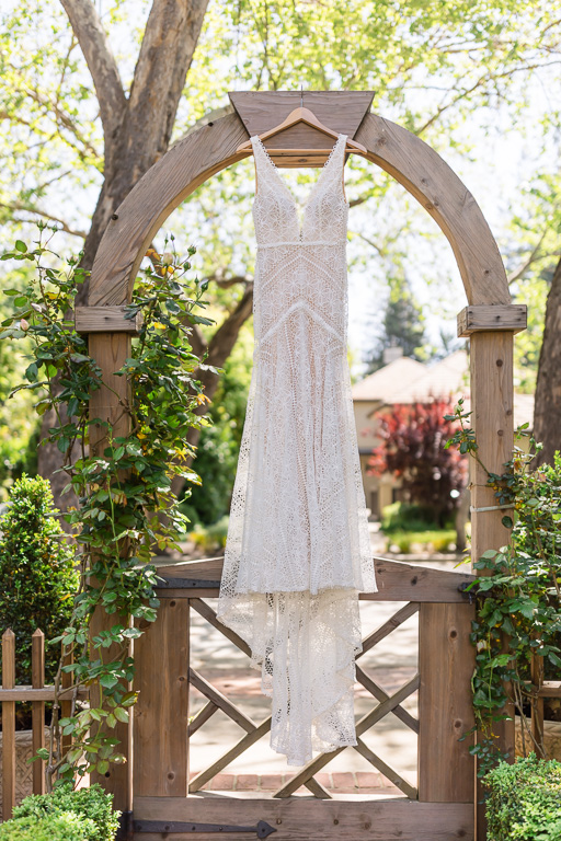 wedding dress photo hanging above garden gate