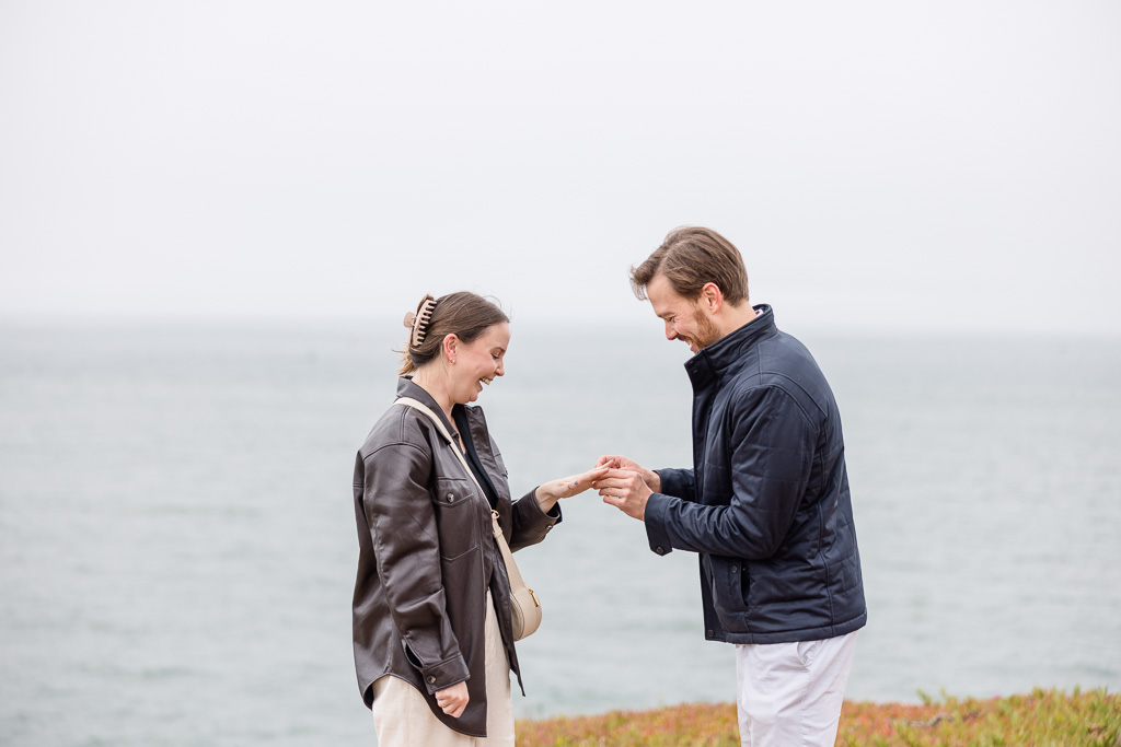 a happy moment of putting on the ring after proposal